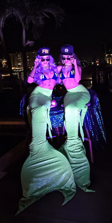 Two themed glamour mermaids posing at a corporate party