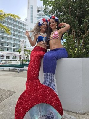 Two Fourth of July mermaids in red, white and blue at a resort