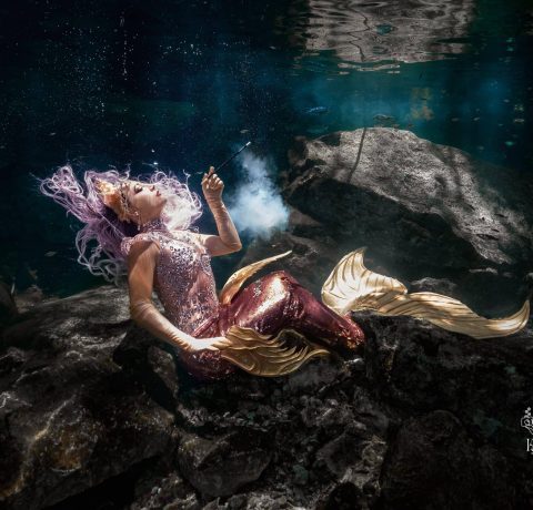 Great Gatsby-inspired mermaid posing underwater with a cigarette prop