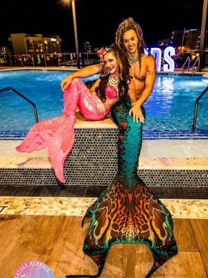 Professional merman and mermaid posing at a corporate event
